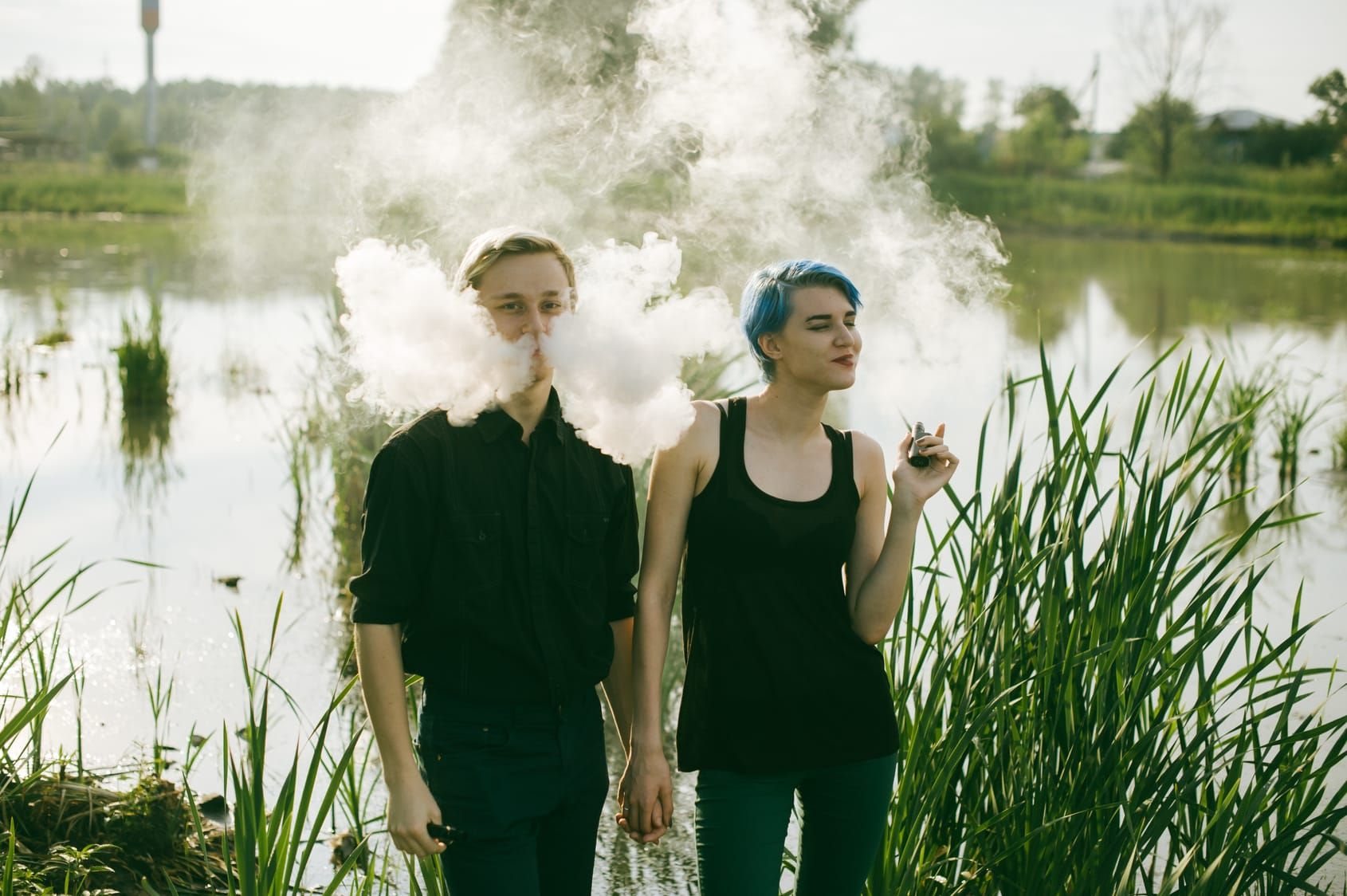 young couple with dyed hair smoking electronic cigarettes on the lake | electric tobacconist uk