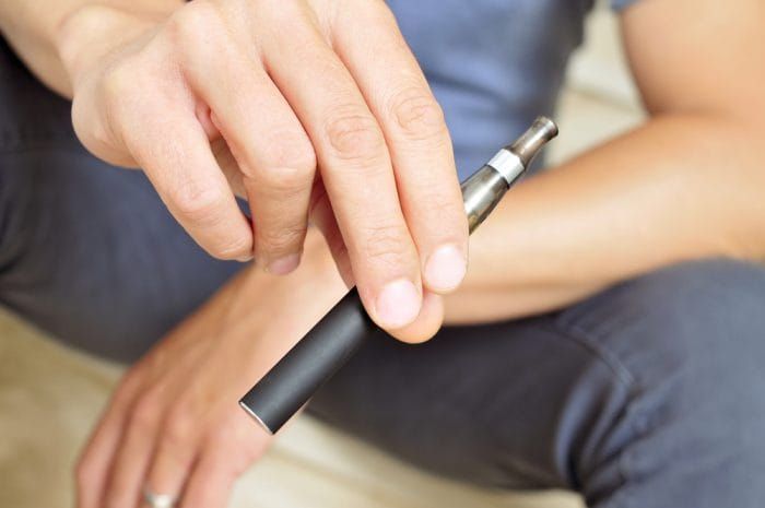 young man vaping with an electronic cigarette - Image