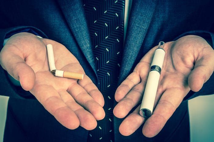 Businessman offers a choice between tobacco cigarette and electronic cigarette - retro style
