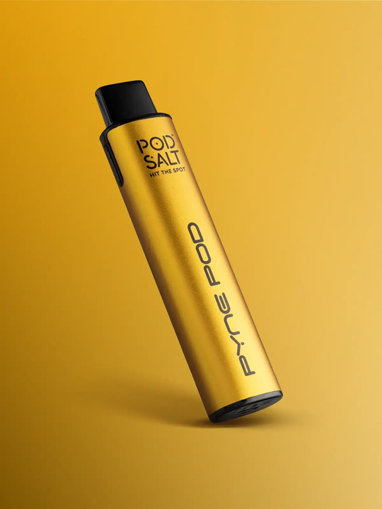 A Pod Salt Pyne Mango Edition device, golden-yellow in colour, leaning in front of a yellow-gold background.