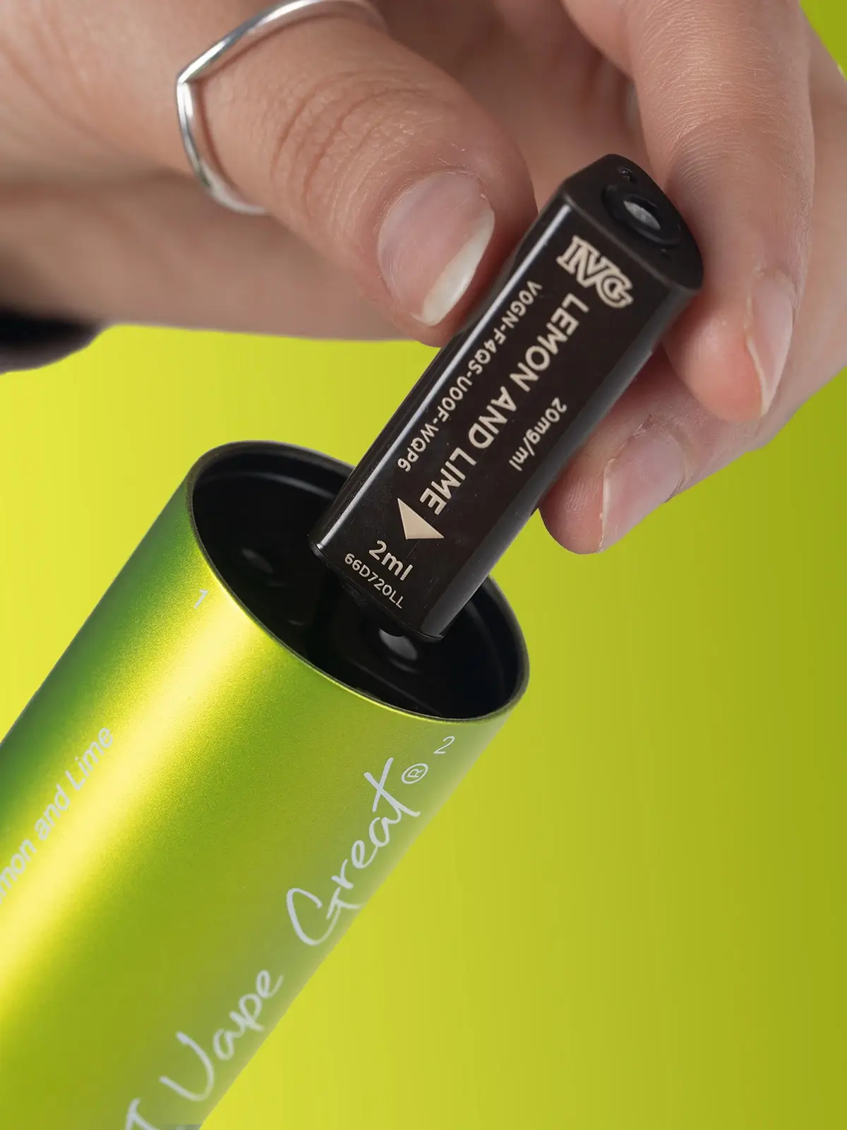A zoomed-in photo of a Lemon and Lime IVG 2400 vape, demonstrating how the e-liquid capsules are inserted before use. Green background.
