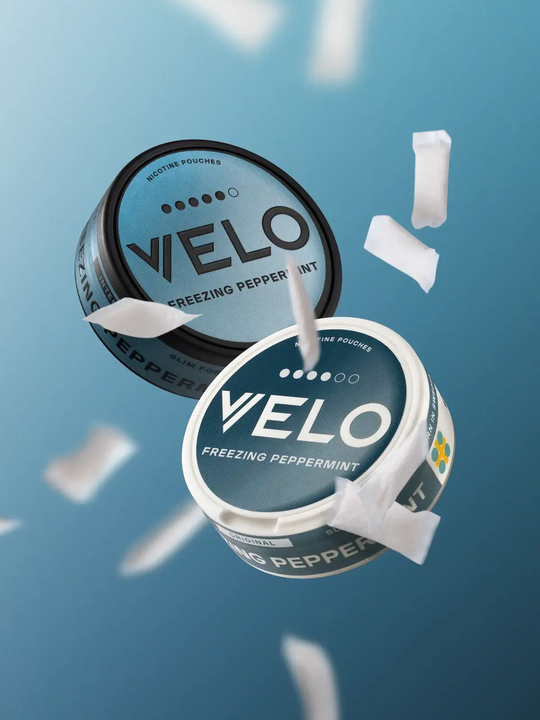 Two tubs of VELO Freezing Peppermint floating on a blue background