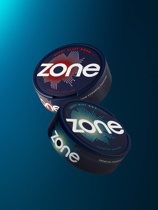 A can of Berry Blast Zone pouches and a can of Sweet Mint Zone pouches floating side by side on a dark blue background.
