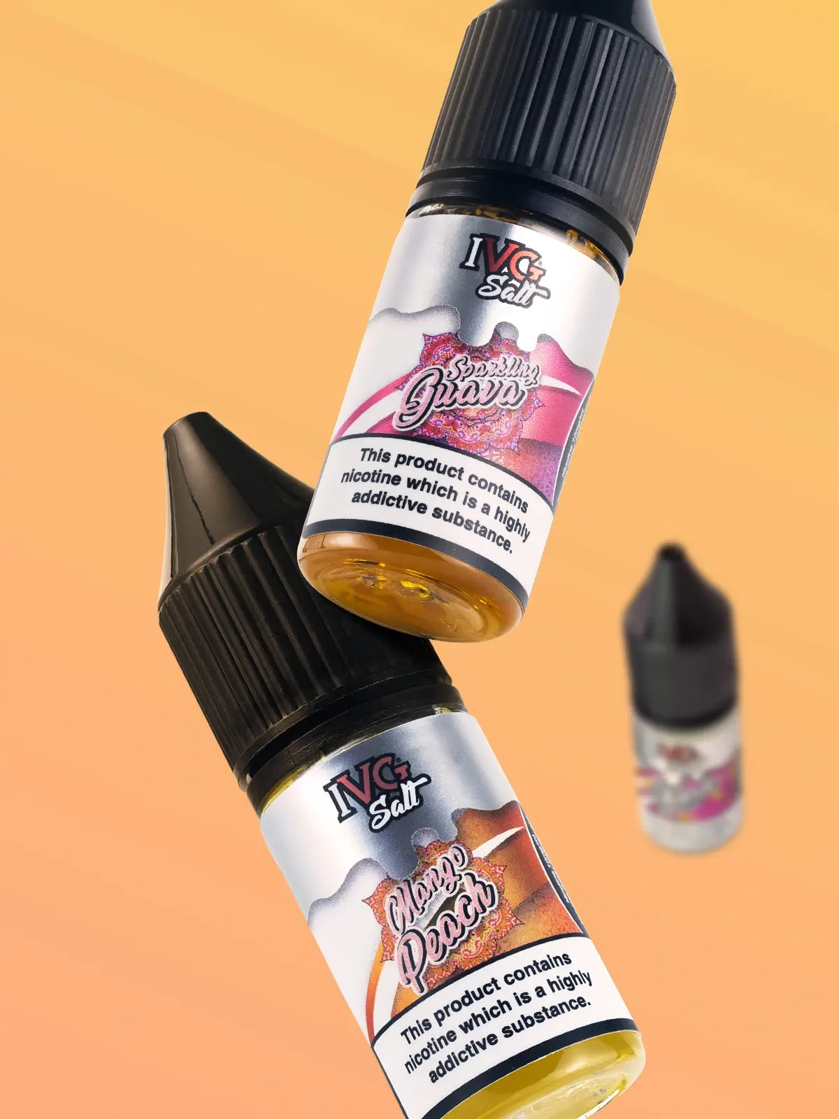 Three bottles of IVG e-liquid (one out of focus) featuring Sparkling Guava and Mango Peach flavours