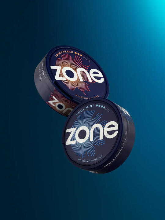 A tub of Juicy Peach Zone nic pouches and a tub of Cool Mint Zone pouches floating side by side on a dark blue background.