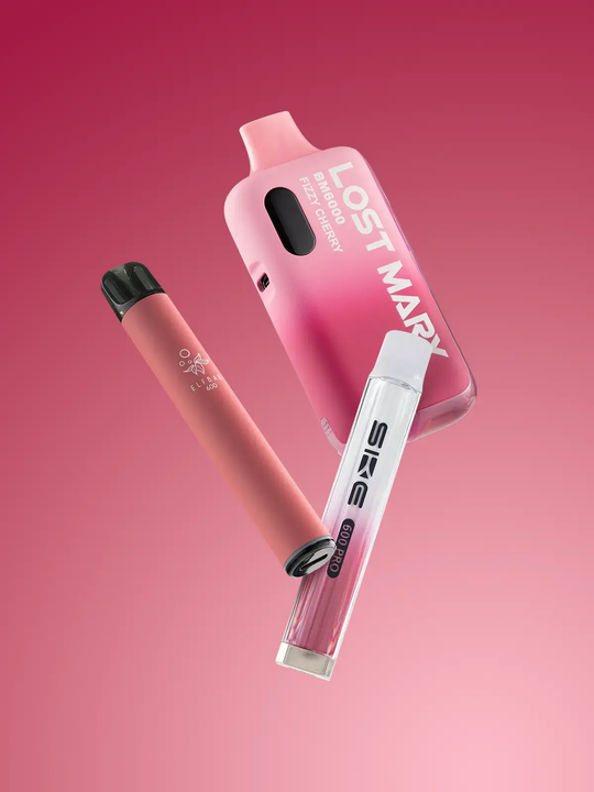 A pink Elf Bar 600 pod kit, a pink Lost Mary BM6000 pod kit, and a white-pink SKE Crystal 600 Pro pod kit floating side by side on a pink background
