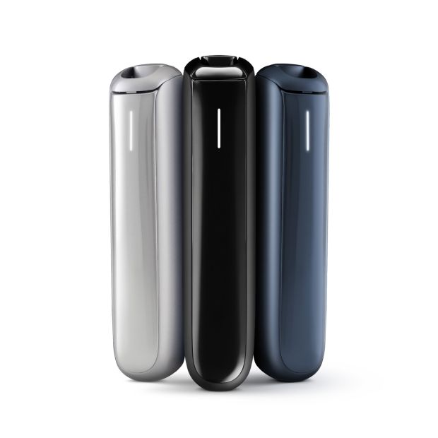 Three Ploom Aura kits stood side by side on a white background; the left device is silver, the middle is black, and the right is navy blue.
