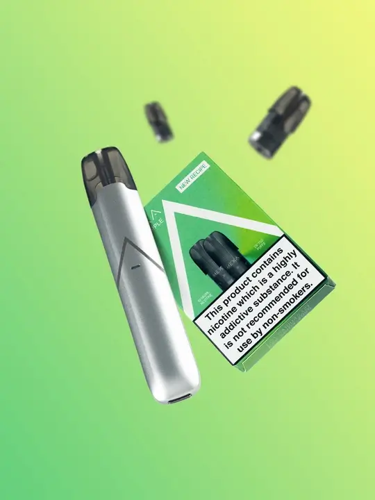 A silver Hexa device and a pack of Mint nic salt pods with a couple of loose pods out of the focus in the background, floating in front of a green background